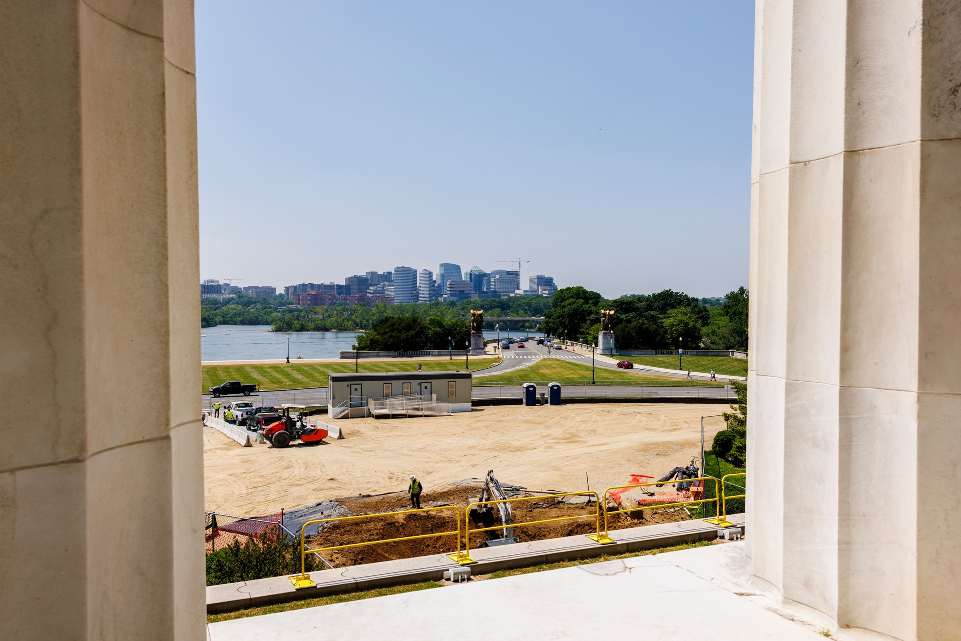 Construction site by the Lincoln Memorial colonnade in Washington, D.C. Urban skyline stretching over the Arlington bridge